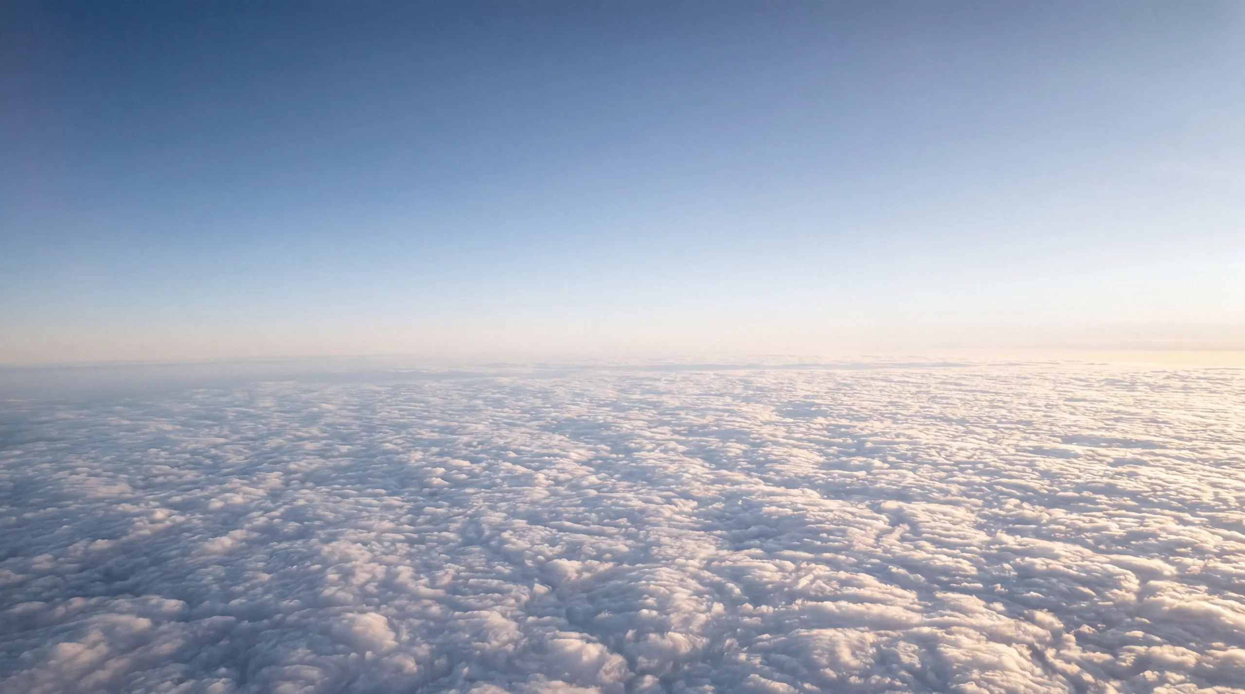 Above a sea of white clouds at 10,000 metres under a clear blue sky